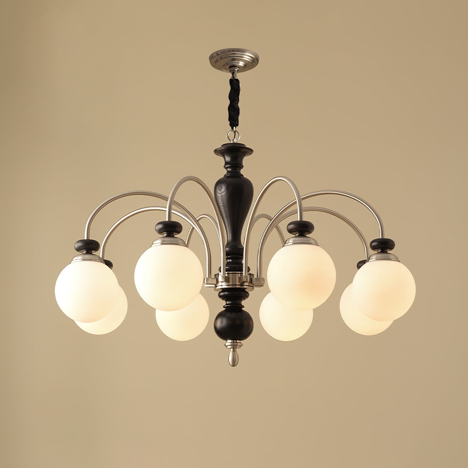 Black nickel chandelier with curved arms lit warmly