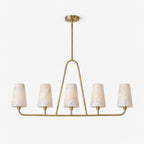 Angled view on a plain white background, the brushed brass oval rail of this Clérachic chandelier holds five alabaster cone shades.