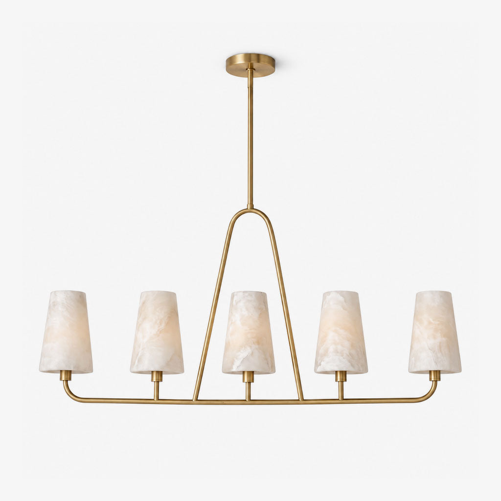 Angled view on a plain white background, the brushed brass oval rail of this Clérachic chandelier holds five alabaster cone shades.