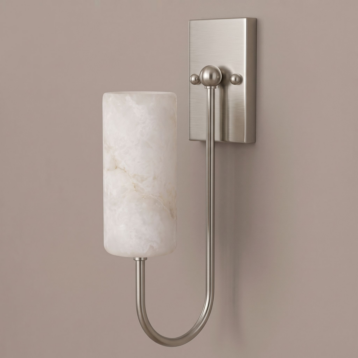 On a plain taupe backdrop, this brushed nickel Clérachic sconce glows, its cylindrical shade catching the light.