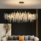 Lit above a cream sofa on a black panelled wall, beside a gold bird-motif artwork.
