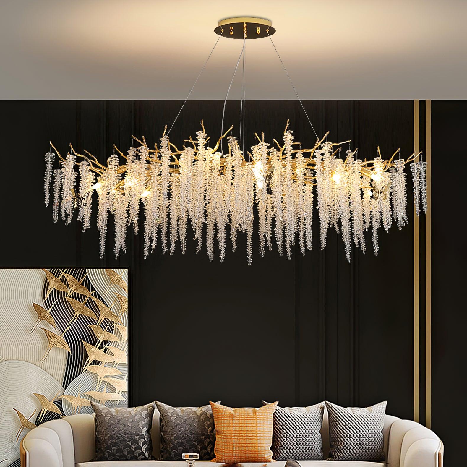 Lit above a cream sofa on a black panelled wall, beside a gold bird-motif artwork.