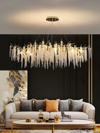 Wider view of the same room, the chandelier's crystal strands lit above a low coffee table.