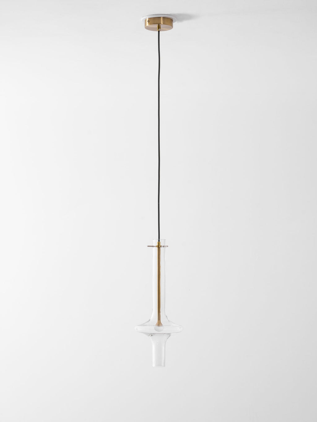 A single gold-stemmed Clérachic pendant in clear glass hangs unlit on a long drop against a plain white backdrop.