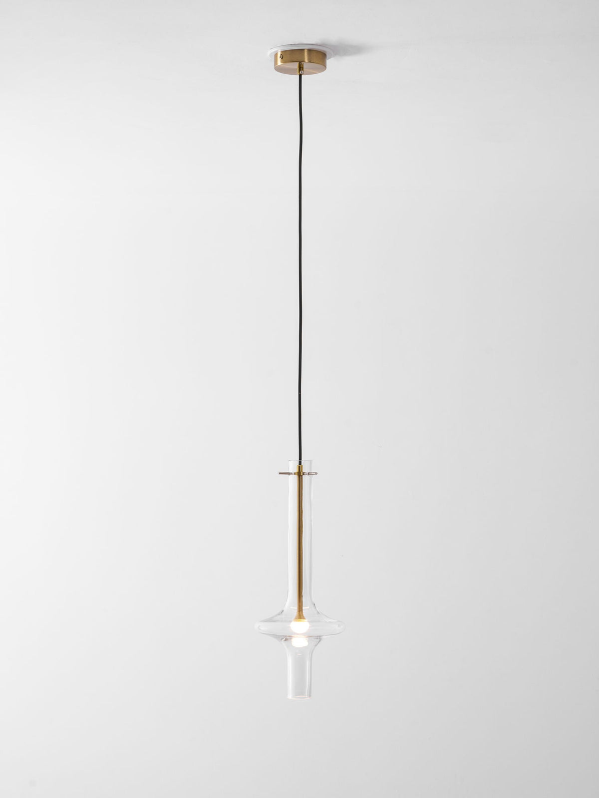 A single gold-stemmed Clérachic pendant in clear glass hangs unlit on a shorter drop against a plain white backdrop.