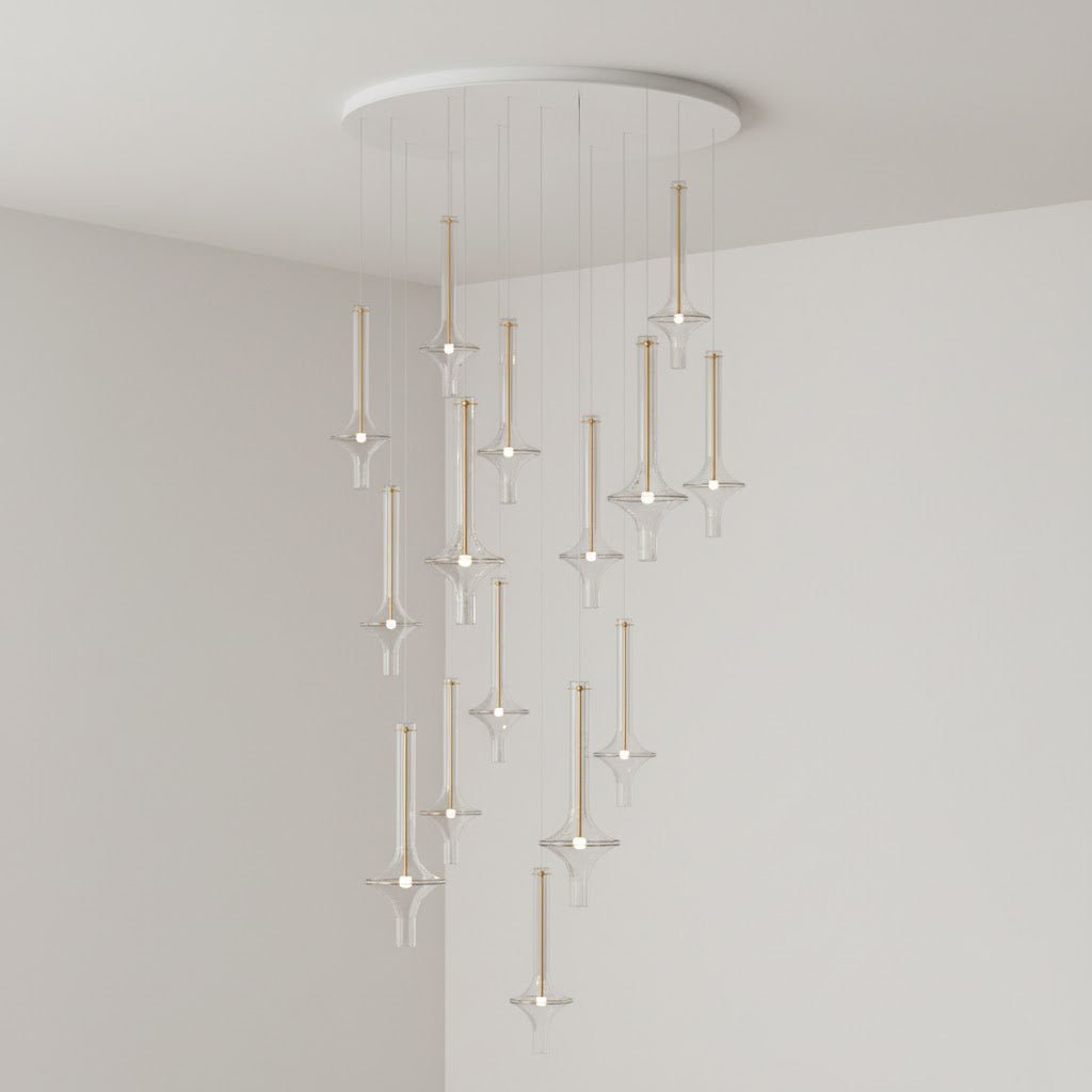 Clérachic pendants in mixed clear and tinted glass spiral downward from a round canopy, lit in the corner of a grey room.