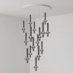 Black-stemmed Clérachic pendants cascade from a round canopy against a darker grey backdrop, glass heads lit in the room corner.