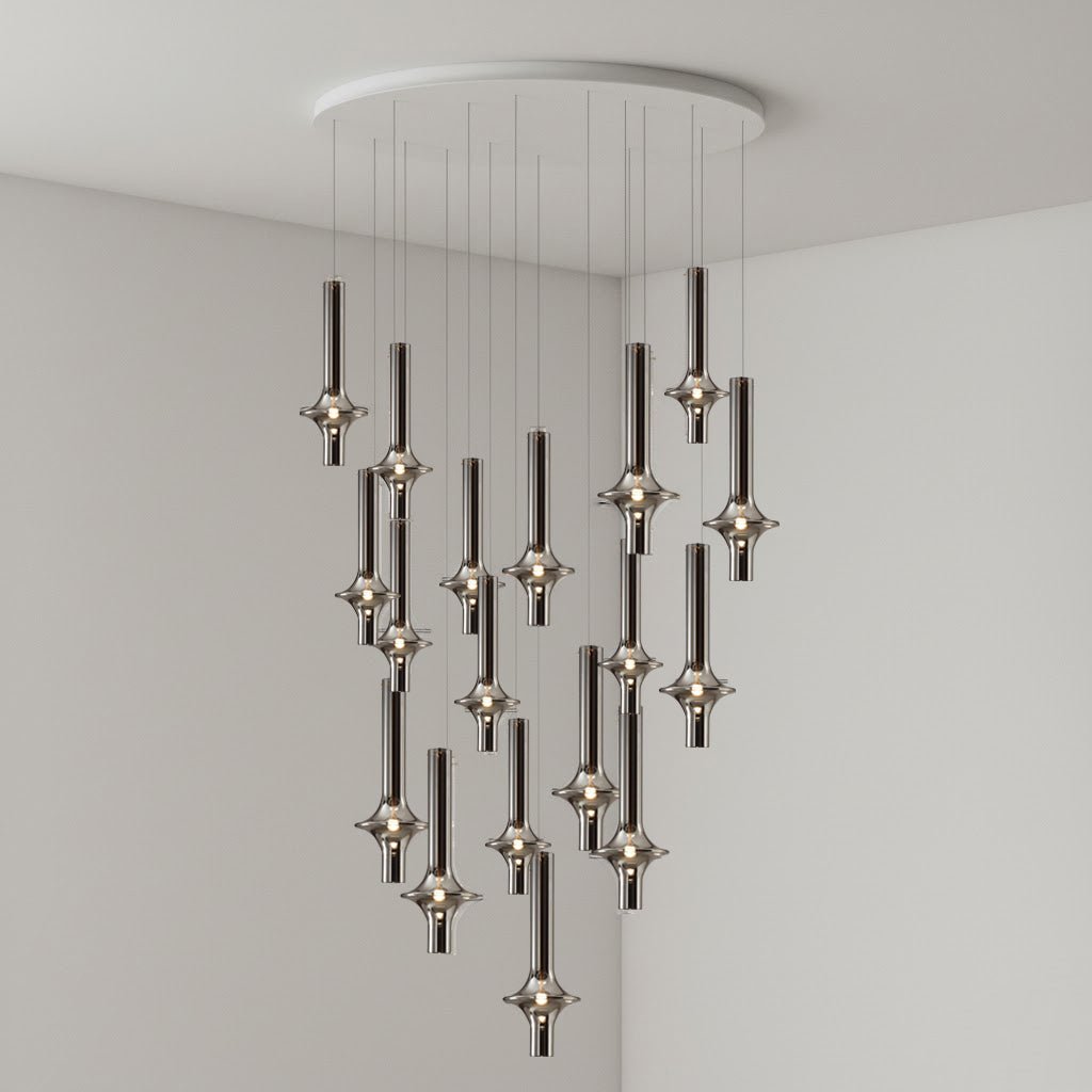 Black-stemmed Clérachic pendants spread wide from a round canopy, lit in clear glass against the corner of a grey room.