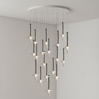 Black-stemmed Clérachic pendants hang with their lit bulb tips prominent, dropping from a round canopy in a grey corner room.