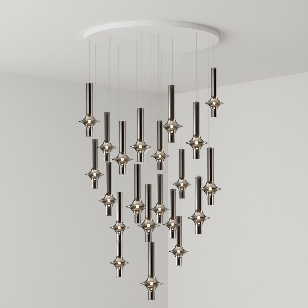 A dense cluster of black-stemmed Clérachic pendants cascades from a round canopy, lit in clear glass in a grey corner room.