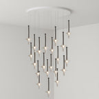 A dense grid of black-stemmed Clérachic pendants in clear glass drops from a round canopy, lit in a grey corner room.