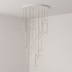 Gold-stemmed Clérachic pendants scatter vertically from a round canopy, lit in clear glass in the corner of a grey room.