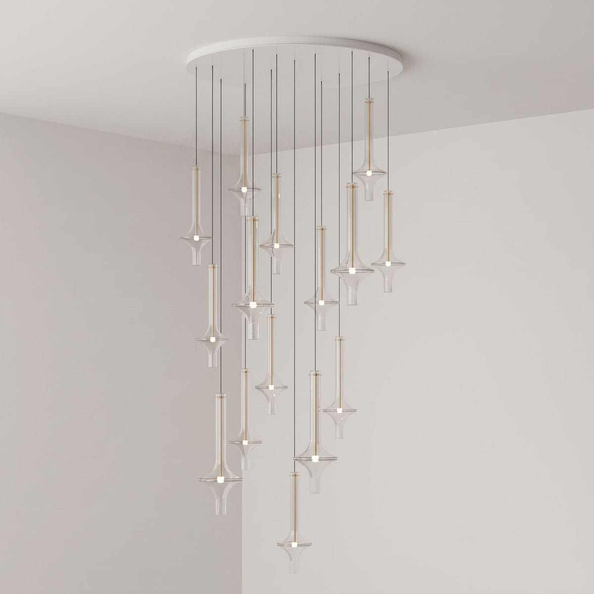 Gold-stemmed Clérachic pendants scatter vertically from a round canopy, lit in clear glass in the corner of a grey room.