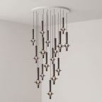 Black-stemmed Clérachic pendants gather toward the centre of their spread, lit in clear glass in a grey corner room.