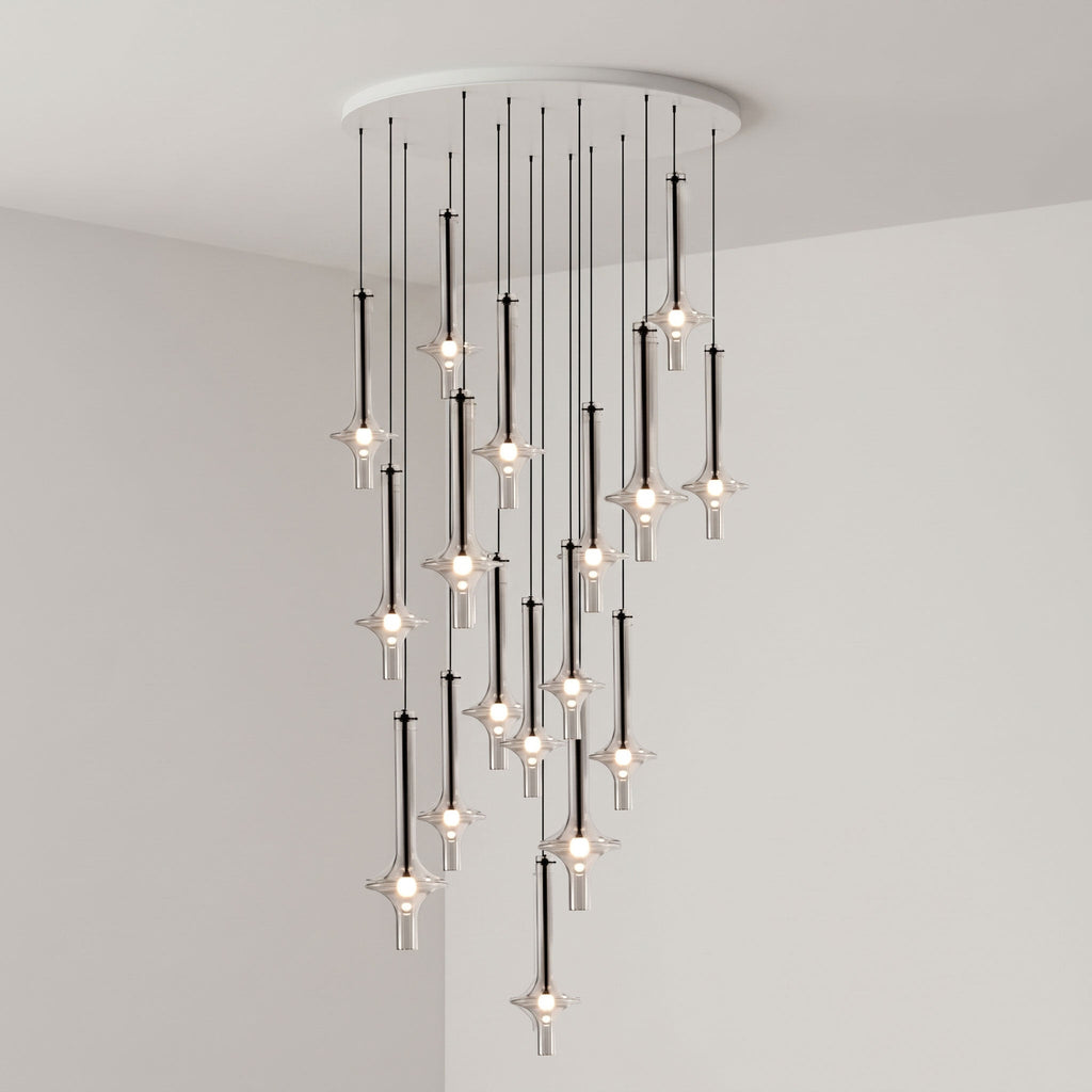 Black-stemmed Clérachic pendants spread wide at varied heights from a round canopy, lit in the corner of a grey room.