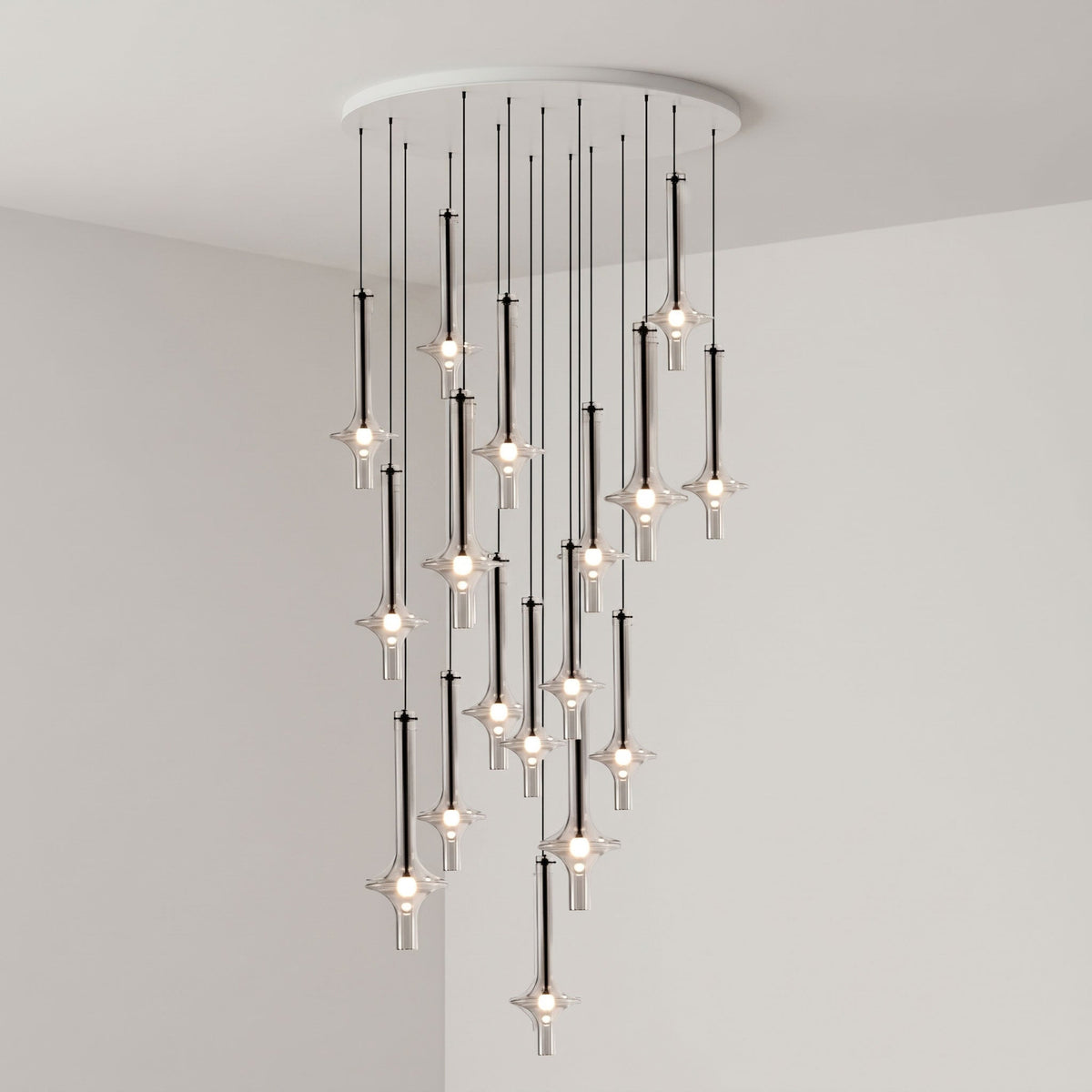 Black-stemmed Clérachic pendants spread wide at varied heights from a round canopy, lit in the corner of a grey room.
