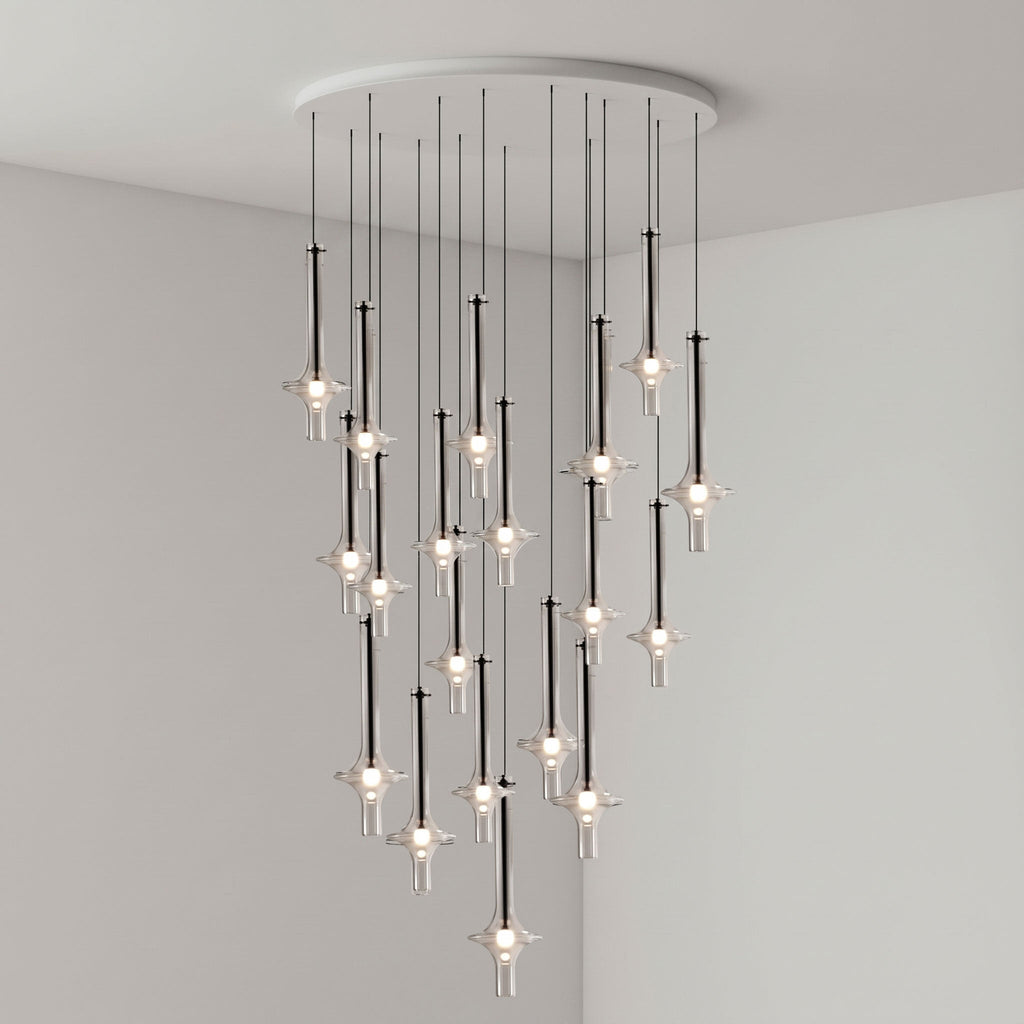 Black-stemmed Clérachic pendants gather densely near the centre of the cluster, lit in clear glass in a grey corner room.