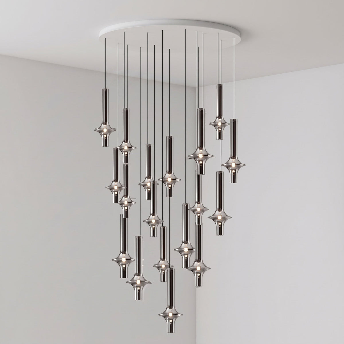 A sparser group of lit black-stemmed Clérachic pendants drops from a round canopy in the corner of a plain grey room.