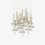 Many gold-stemmed pendants in clear and smoky glass hang together in this Clérachic cluster shot on a plain white backdrop.