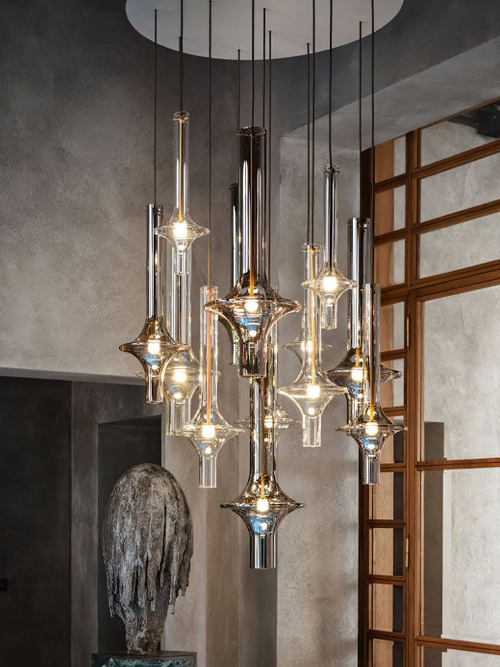 A wider view shows lit Clérachic pendants clustered in a stone-walled room, beside a timber lattice door and stone sculpture.