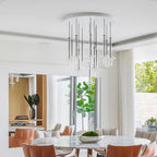 A cluster of Clérachic pendants in clear and nickel-toned glass hangs from a round ceiling plate above a dining table with tan chairs.