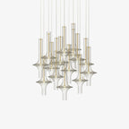A dense cluster of gold-stemmed Clérachic pendants in clear glass is shown unlit against a plain cream backdrop.