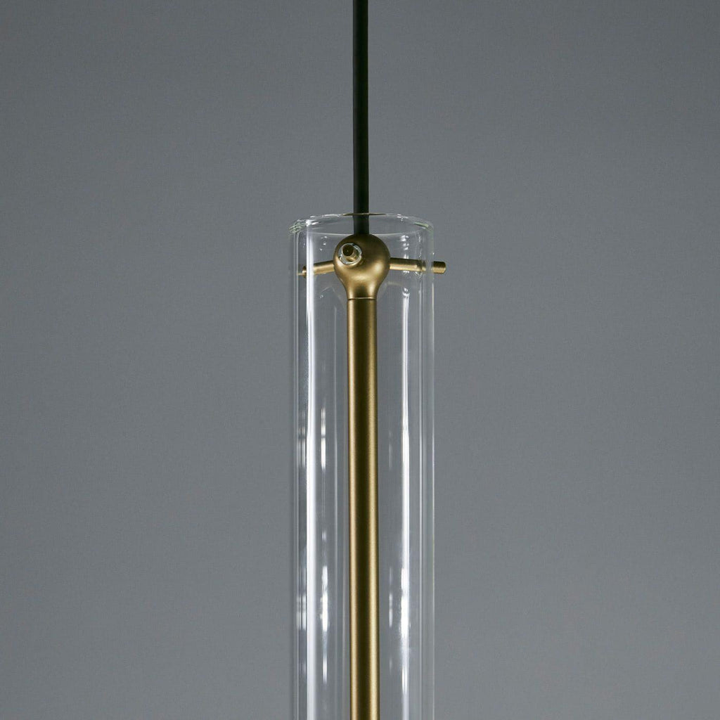 A close view of this Clérachic pendant's neck shows the brass cross-bar fitting against its clear glass tube.