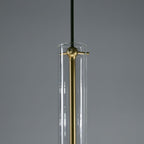 A close view of this Clérachic pendant's neck shows the brass cross-bar fitting against its clear glass tube.