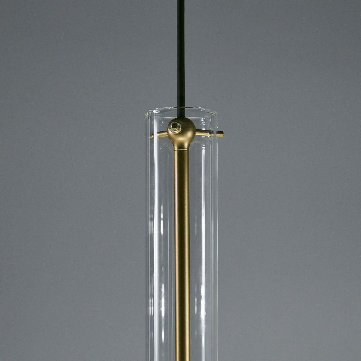 A close view of this Clérachic pendant's neck shows the brass cross-bar fitting against its clear glass tube.