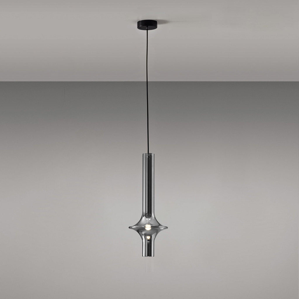 A single black-stemmed Clérachic pendant in smoky grey glass hangs unlit against a plain grey backdrop, its black canopy visible above.