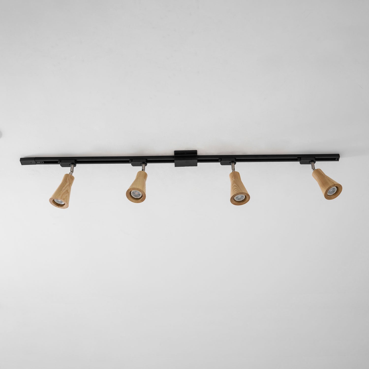 Wood track ceiling lamp with adjustable heads over a living area