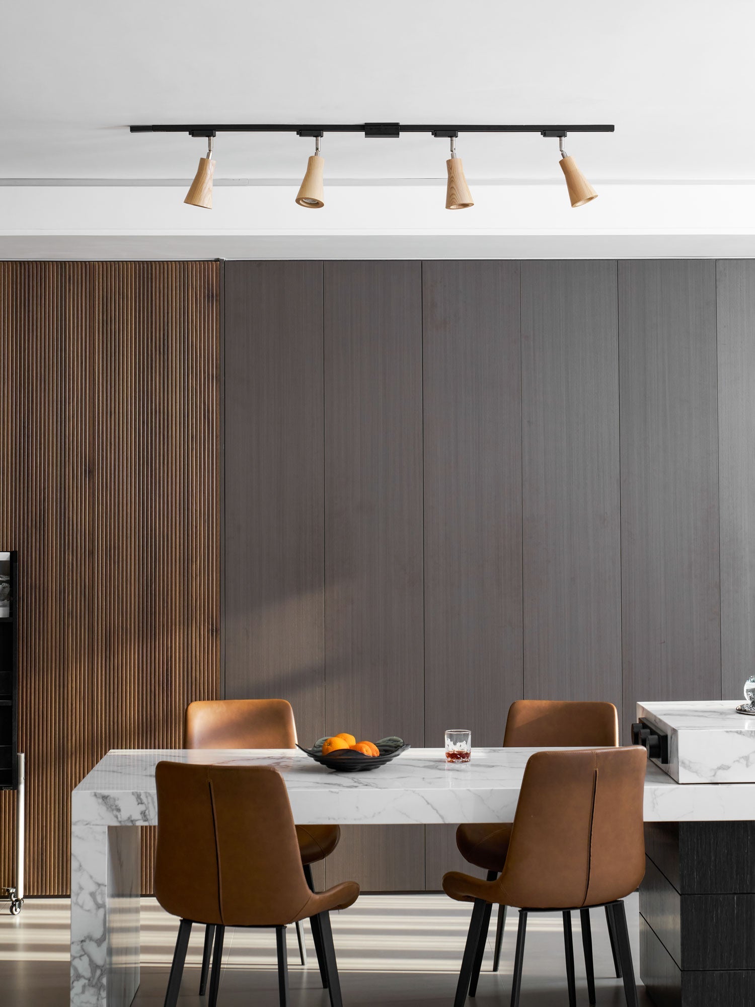 Wood track ceiling lamp angled to wash light down a wall