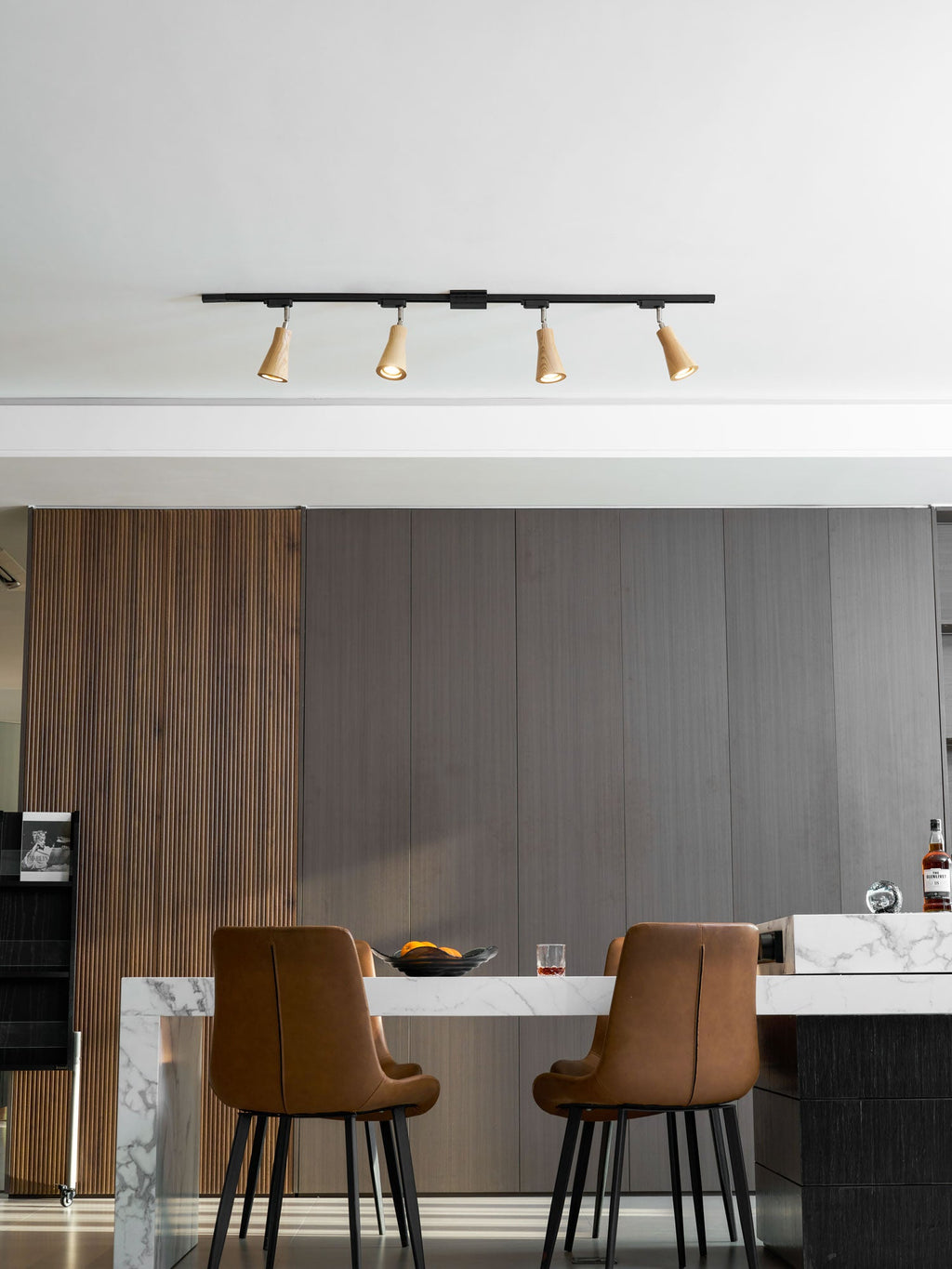 Wood track ceiling lamp lighting a wall as a wall-mounted fixture