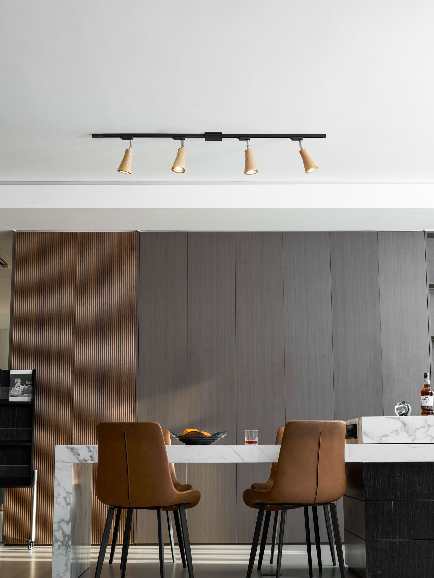 Wood track ceiling lamp lighting a wall as a wall-mounted fixture
