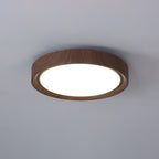 Walnut round ceiling light lit warmly in a living room
