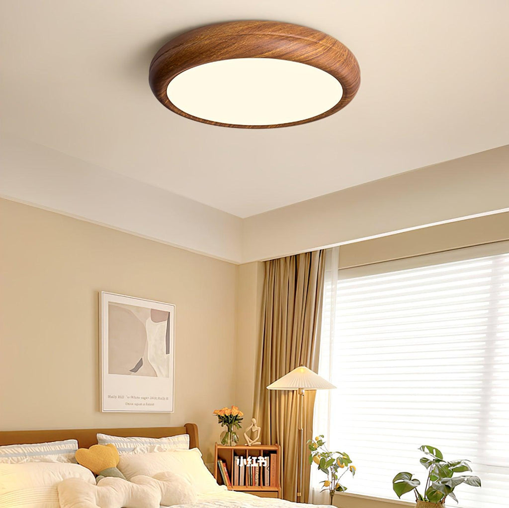 Walnut round ceiling light shown at an angle when lit