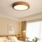 Walnut round ceiling light shown at an angle when lit