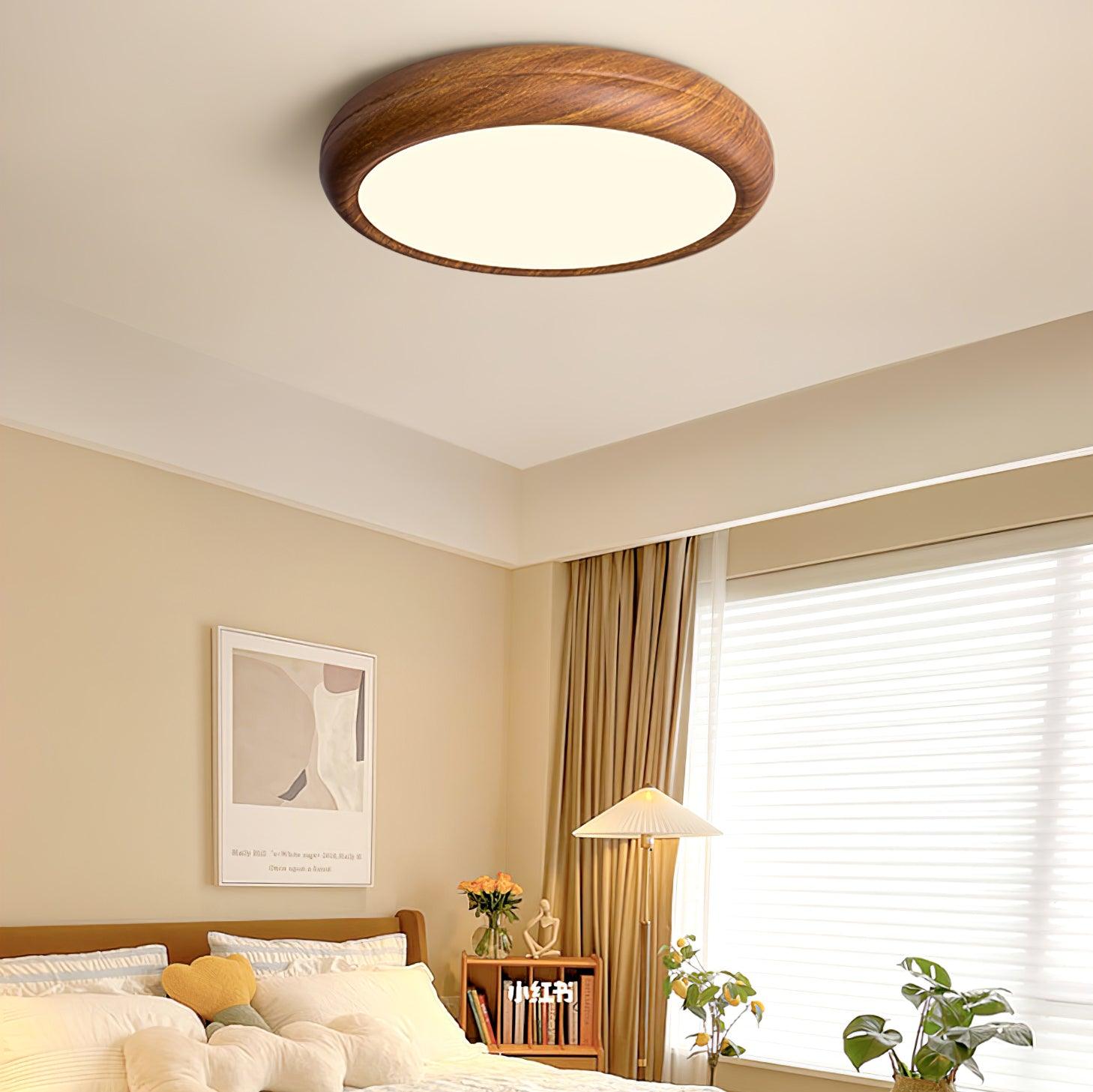 Walnut round ceiling light shown at an angle when lit