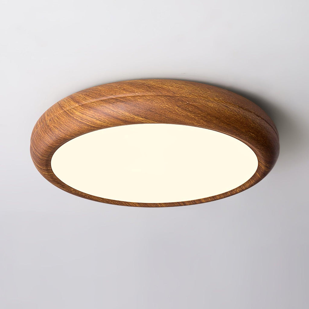 Round walnut ceiling light glowing warmly in evening