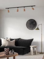 Wood track ceiling lamp angled across a textured wall