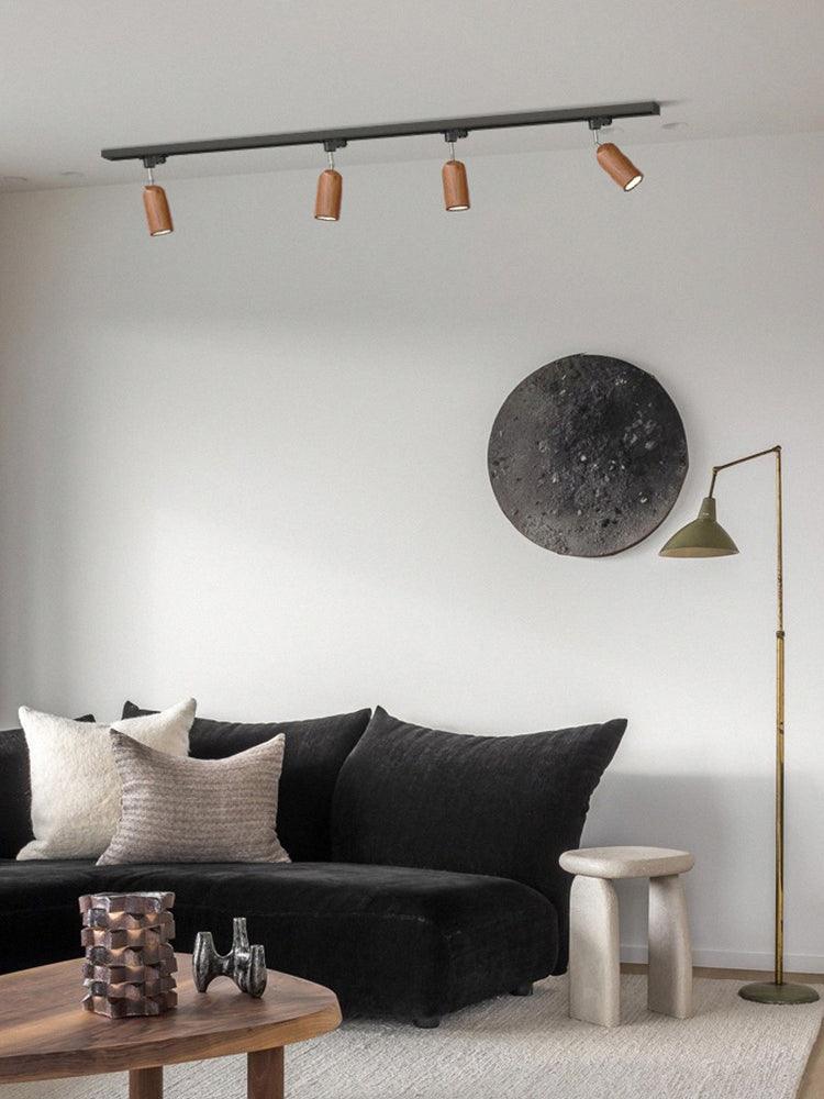 Wood track ceiling lamp angled across a textured wall
