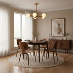 Centred above a round dining table set on a patterned rug, this Clérachic chandelier lights the room in pale wood and opal glass.