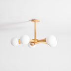 Side view on a plain white background, this Clérachic chandelier's arms extend left and right with an opal globe at each end.