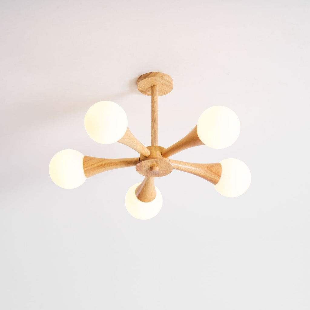 Photographed front-on against a plain white background, this Clérachic chandelier's five opal globes sit evenly around the pale wood centre.
