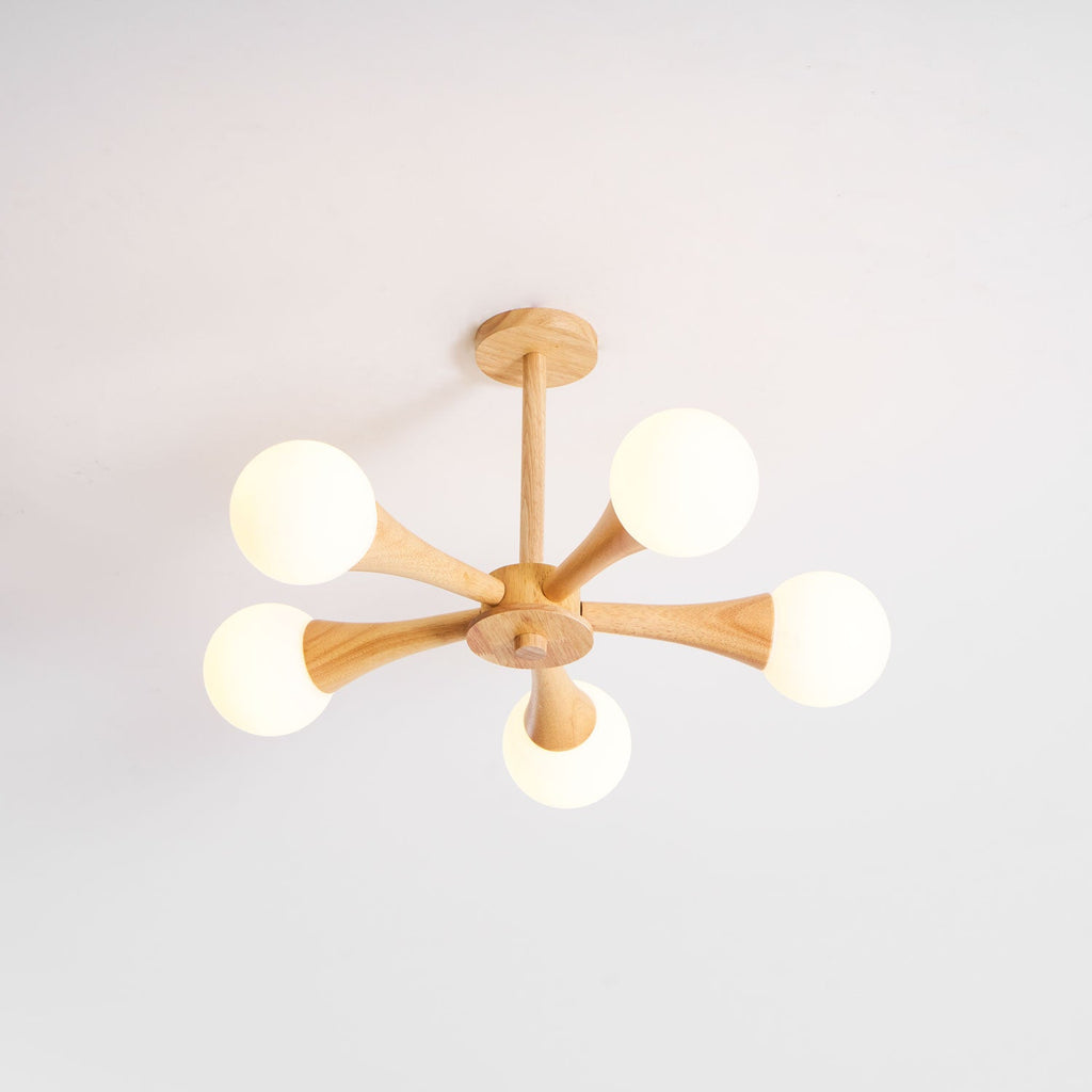 Shown at an angle on a plain grey background, this Clérachic chandelier's pale wood arms hold five unlit opal glass globes.
