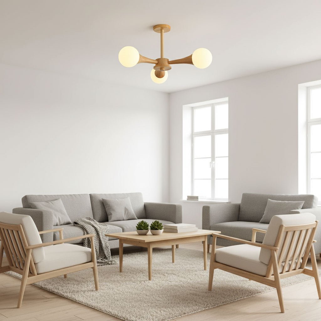 Ceiling-mounted above a grey sofa and pale wood armchairs, this Clérachic chandelier glows softly in a bright living room.