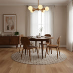 Lit prominently above a round dining table with a patterned rug and a wood sideboard, this Clérachic chandelier shows its full five-arm spread.