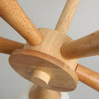 Extreme close-up of the wood ceiling hub of this Clérachic chandelier, showing how each pale wood arm joins the central canopy.