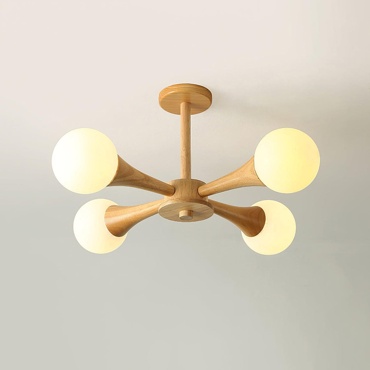 Photographed front-on against a soft grey-beige background, this Clérachic chandelier's pale wood frame and opal globes sit unlit.