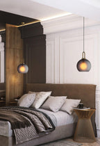 Glass pendant light showing the glowing filament bulb inside